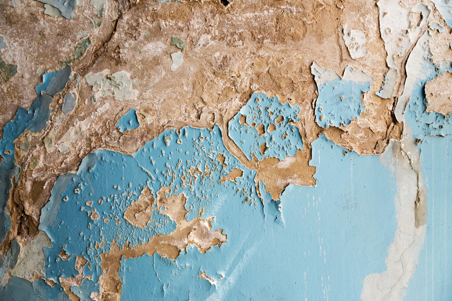 Zbliżenie starej ściany z łuszczącą się farbą i przetarciami