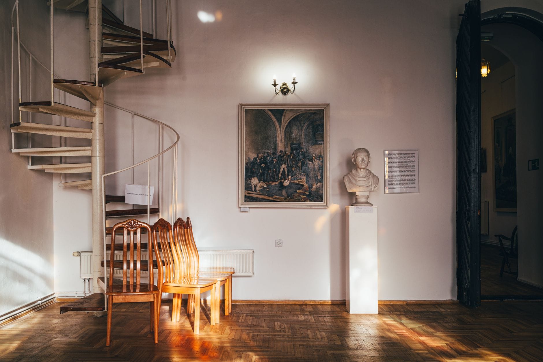 Ciepło oświetlony salon z kręconymi schodami i galerią obrazów
